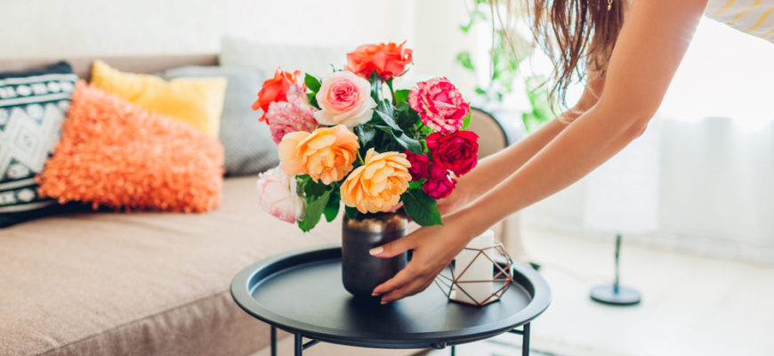 Woman,Puts,Vase,With,Flowers,Roses,On,Table.,Housewife,Taking