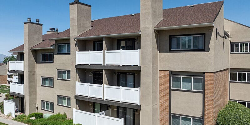 Exterior property view of Foothill Place showing the 3 story building with balcony spaces and surrounding greenery